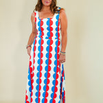 Woman wearing a sleeveless dress with red, white, and blue pattern on a beige background