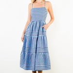 Woman wearing a blue checkered dress against a white background