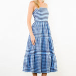 Woman wearing a blue plaid dress against a white background