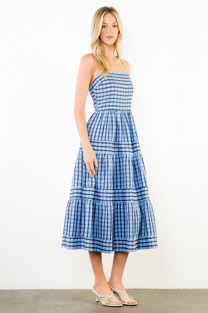 Woman wearing a blue plaid dress against a white background