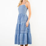 Woman wearing a blue and white checkered dress on a white background