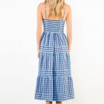 Woman wearing a blue and white checkered dress on a plain background