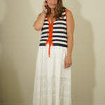 Woman wearing a striped dress with orange accents against a plain background