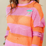 Woman wearing a colorful striped sweater and white shorts against a plain background