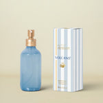 Blue spray bottle with gold cap and striped box labeled 'Artisan Volcano' on a white background