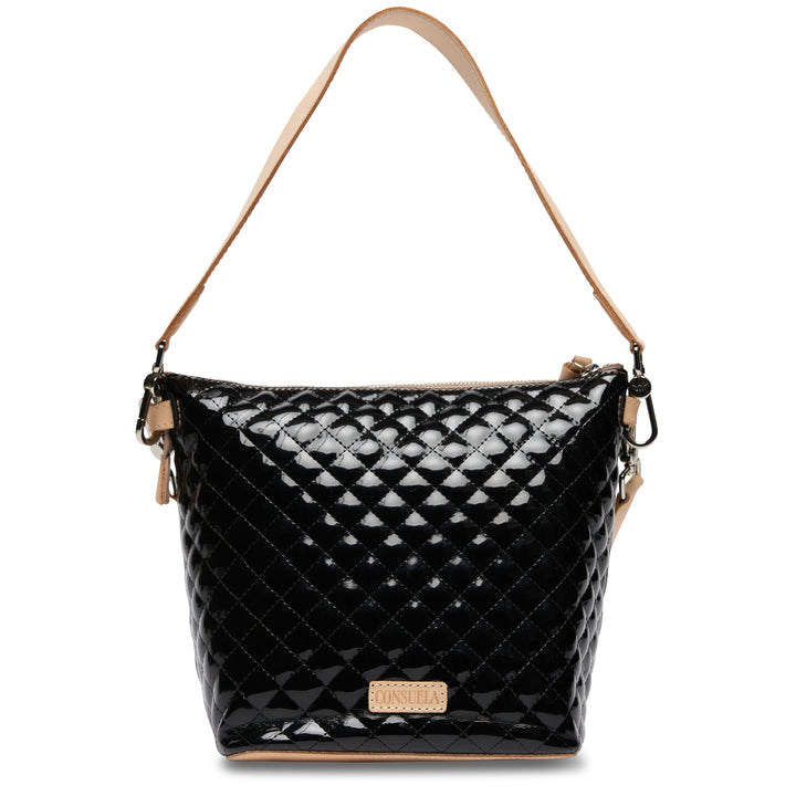 Black quilted handbag with tan handle and strap on a white background