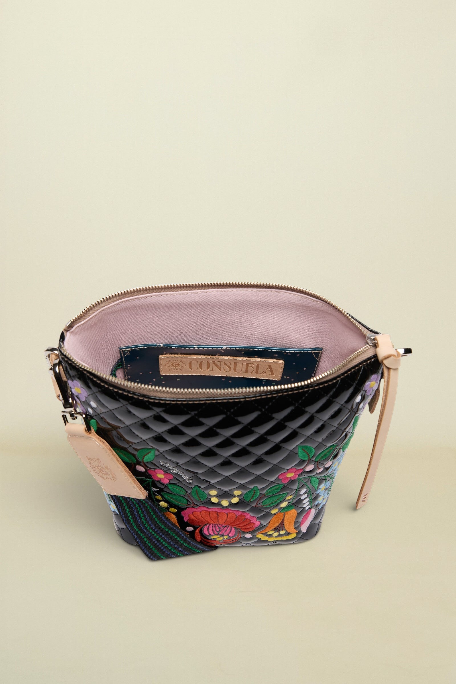 Quilted handbag with floral embroidery and visible brand logo on a white background