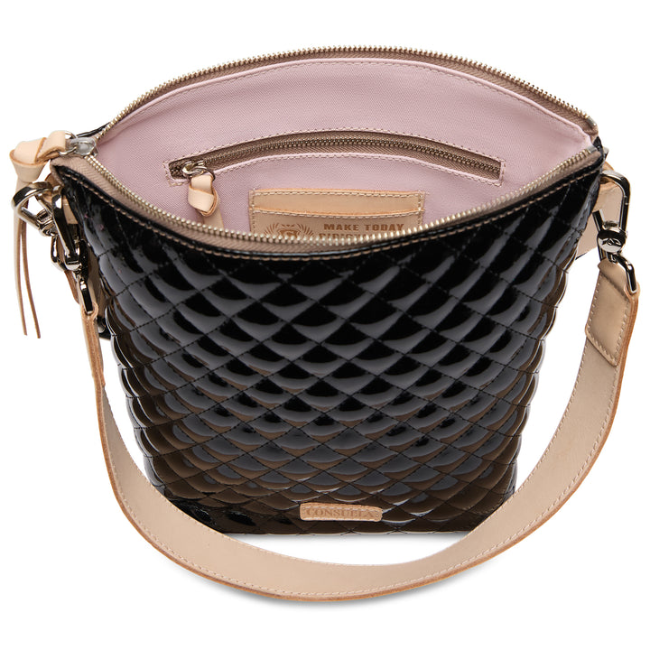 Black quilted handbag with beige interior and strap on a white background