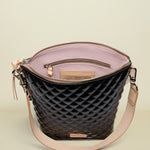 Black quilted handbag with beige interior and strap on a white background