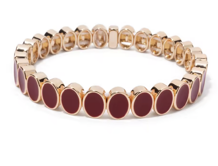 Bracelet with gold and red circular beads on a white background