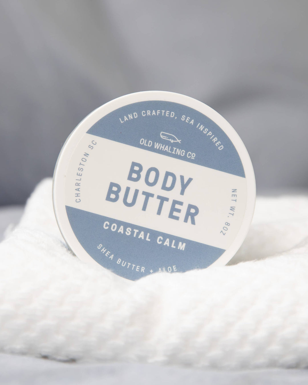Body butter container with a label on a textured surface
