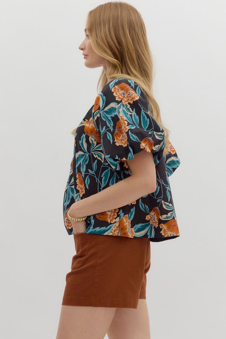 Woman wearing a floral blouse and brown skirt on a white background