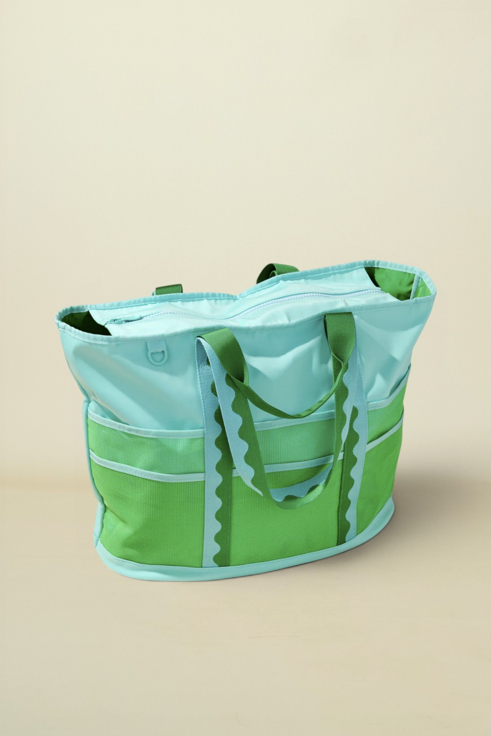 Green and light blue tote bag on a beige background