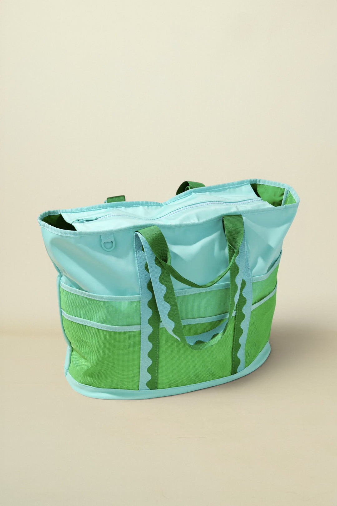 Green and light blue tote bag on a beige background