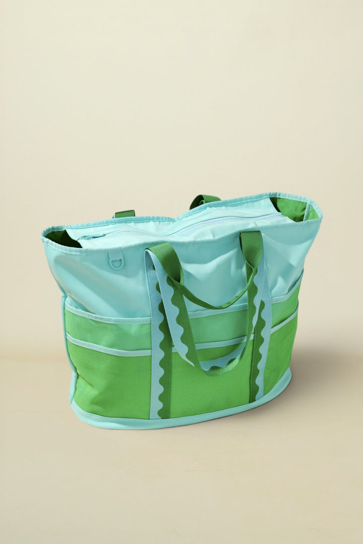 Green and light blue tote bag on a beige background