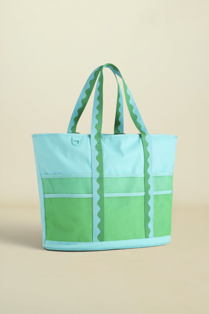 Green and light blue tote bag on a beige background
