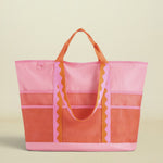 Pink and orange tote bag with ruffled details on a white background