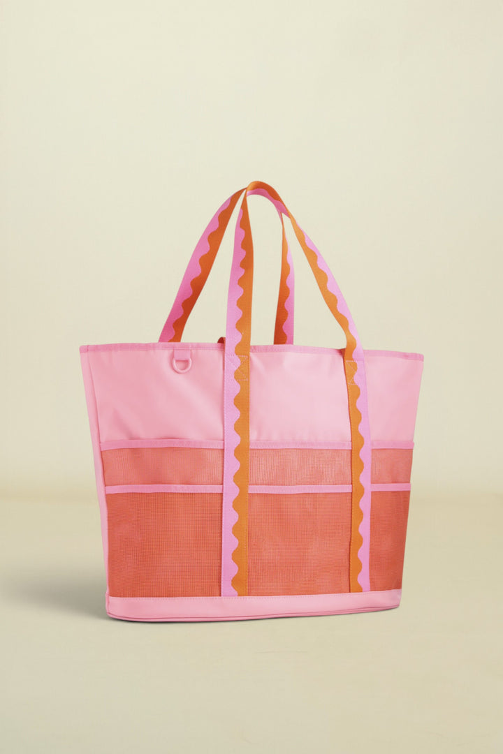 Pink and orange tote bag with striped handles on a white background