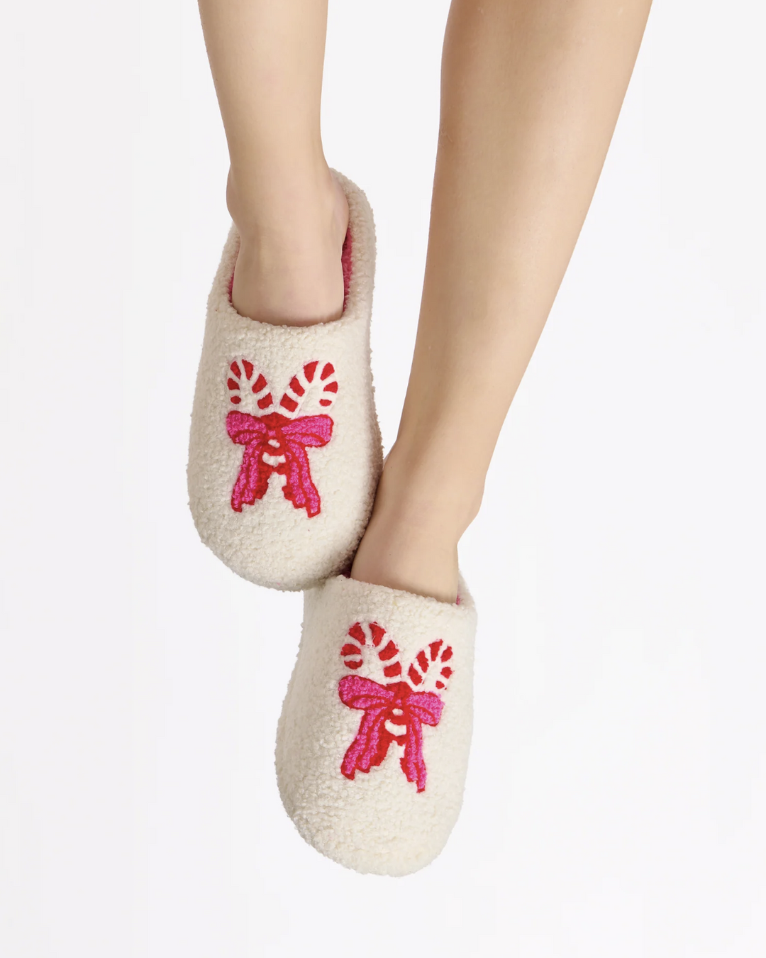White slippers with pink bows on a white background
