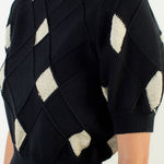 Black sweater with geometric pattern on a white background