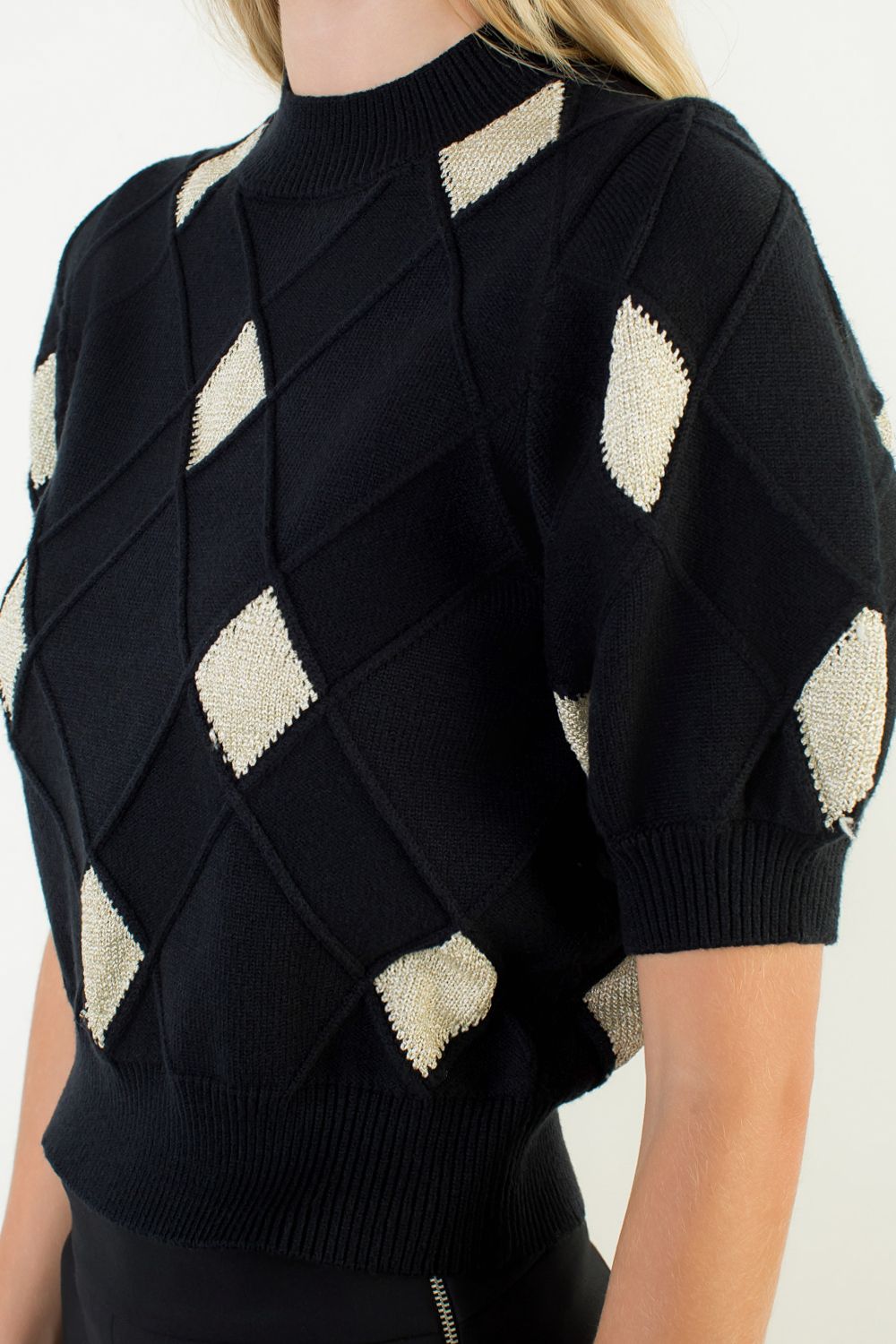 Black sweater with geometric pattern on a white background