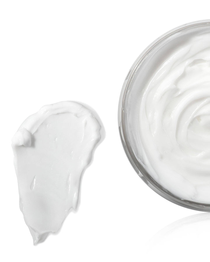 Jar of white cream with a swirl on a white background