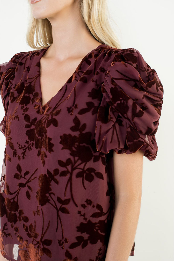 Maroon floral top with ruffled sleeves on a white background