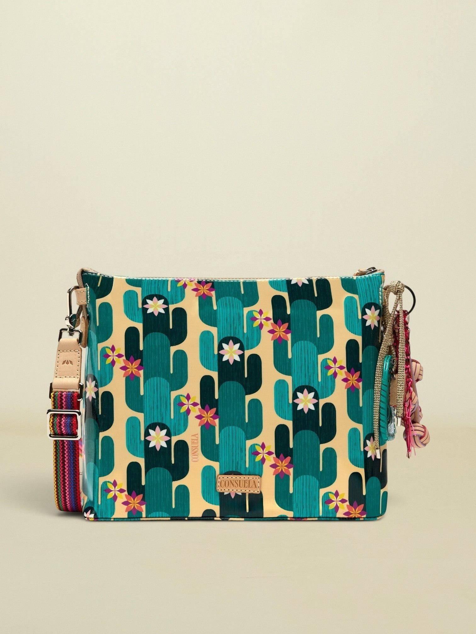 Point of Origin CONSUELA Desi Downtonw crossbody bag with a vibrant cactus print, colorful woven strap, and decorative tassel charm.
