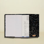 Open notebook with black splatter design on a white background
