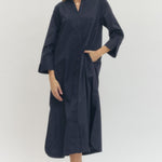 Woman wearing a navy blue dress against a white background