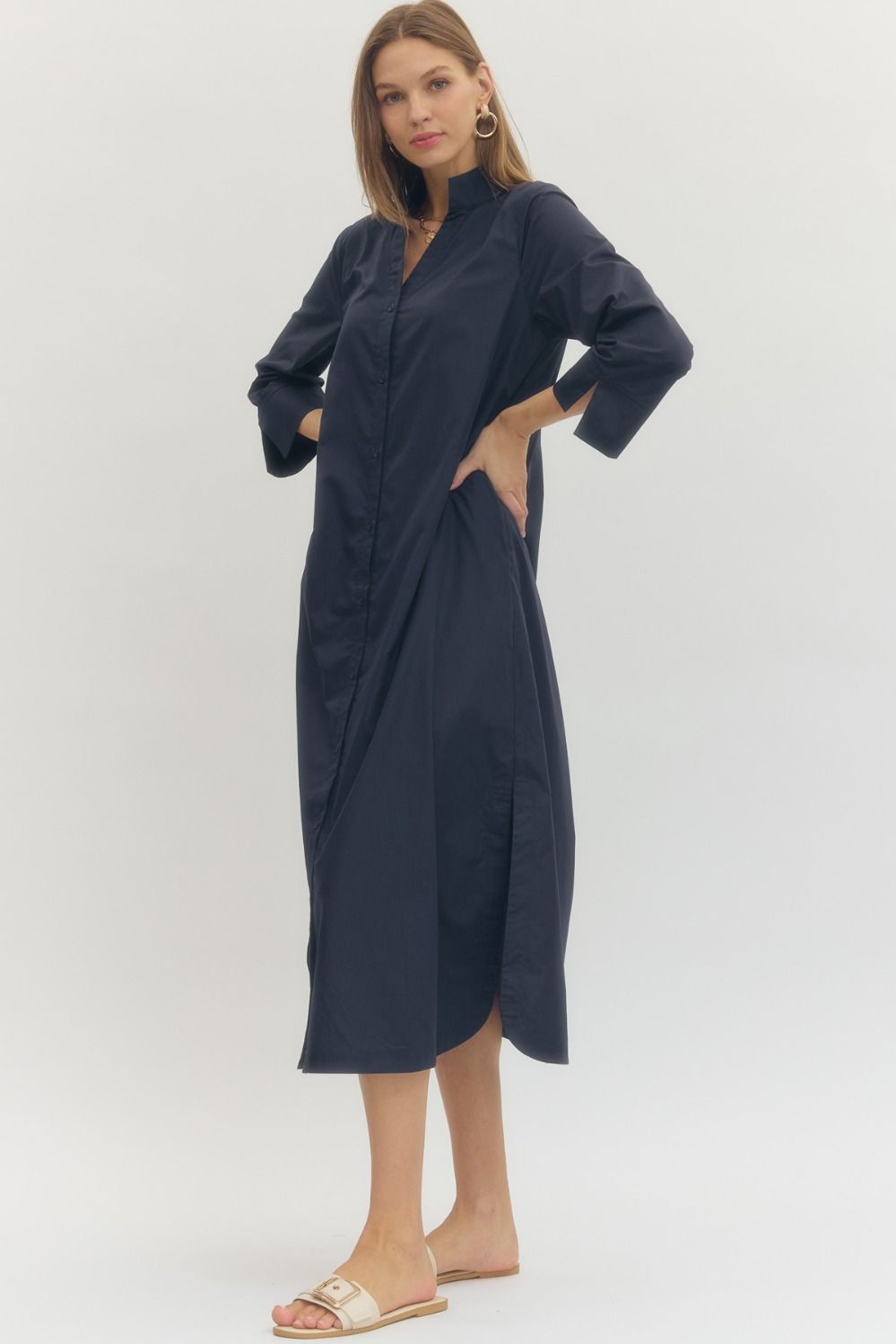 Woman wearing a navy blue dress with cut-out sides on a white background
