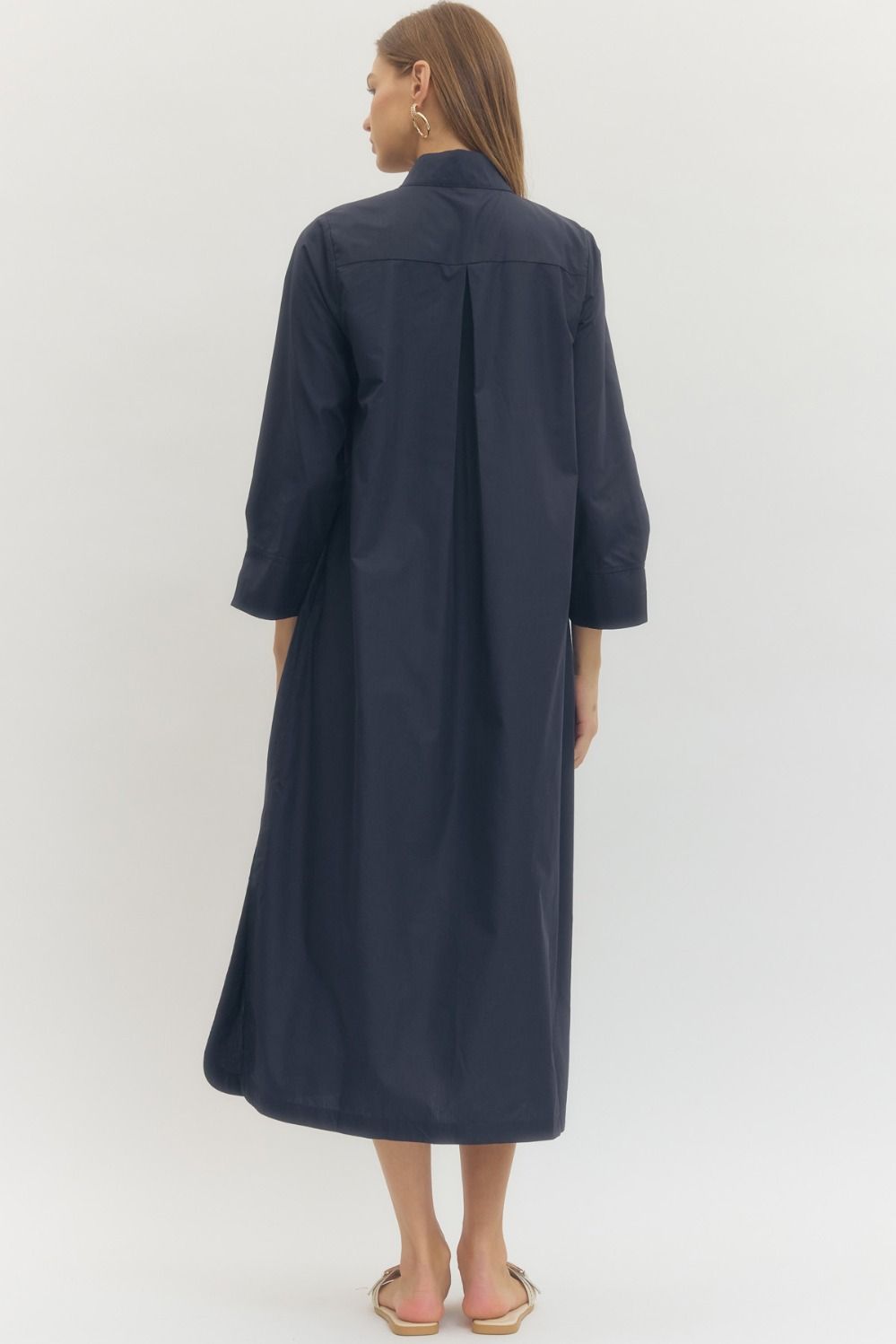 Woman wearing a navy blue dress against a white background