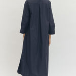 Woman wearing a navy blue dress against a white background