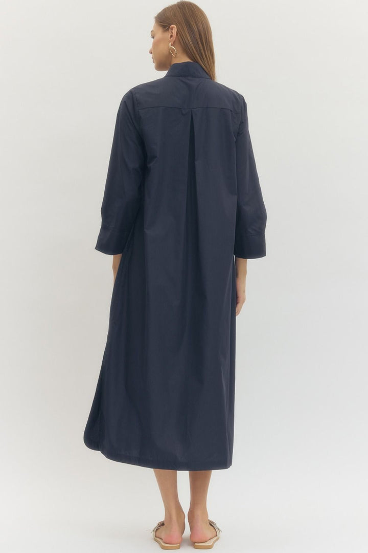 Woman wearing a navy blue dress against a white background