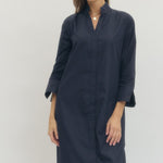 Woman wearing a navy blue dress against a white background