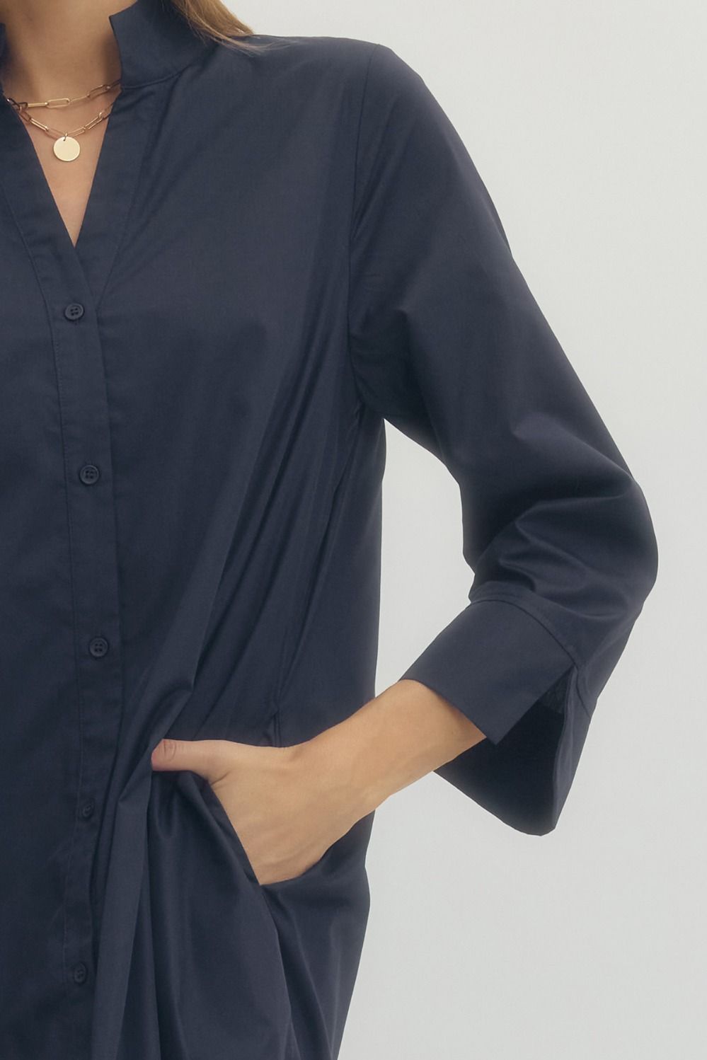 Navy blue shirt worn by a person on a light gray background