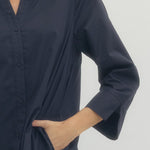 Navy blue shirt worn by a person on a light gray background