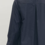 Navy blue coat worn by a person on a white background