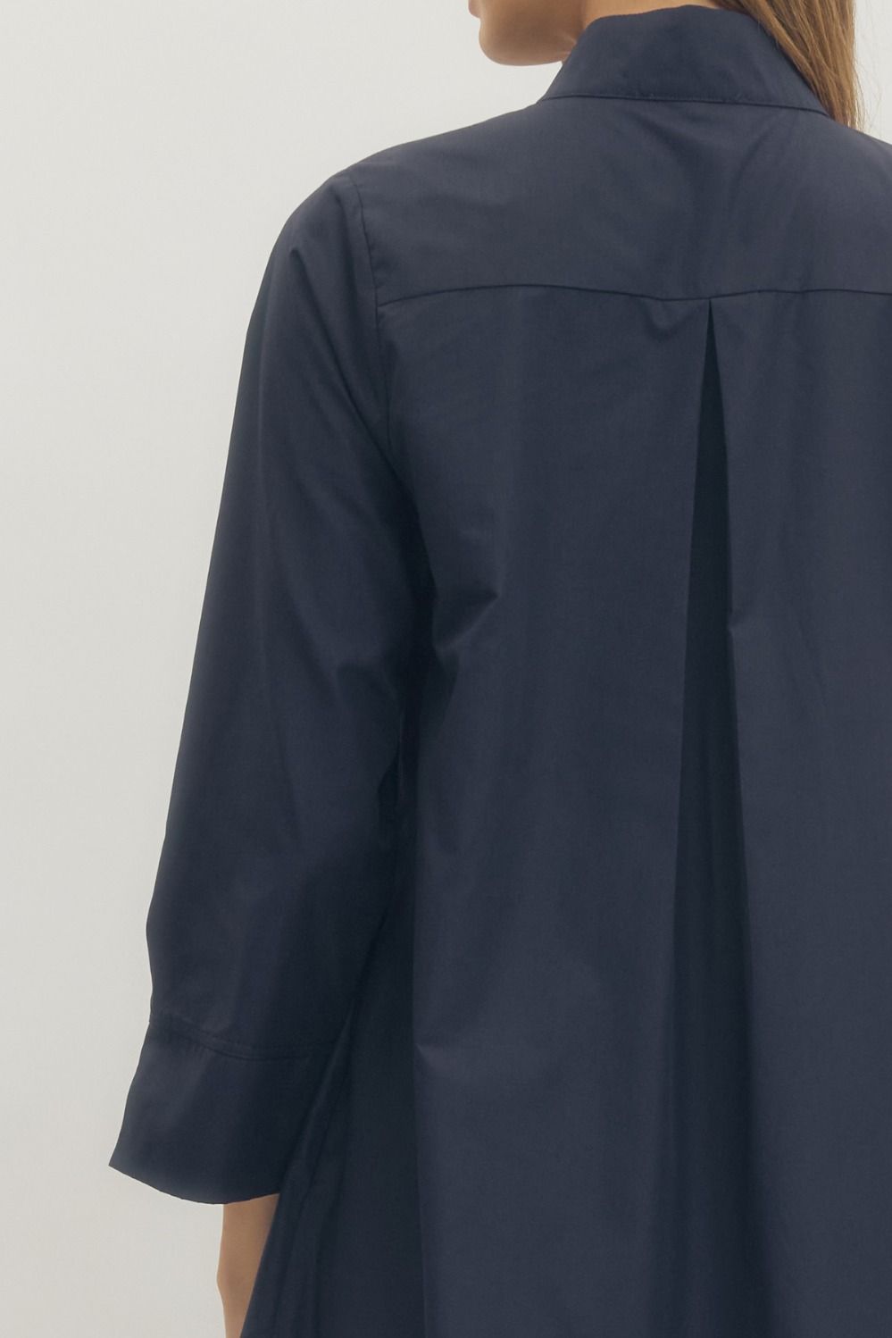 Navy blue coat worn by a person on a white background