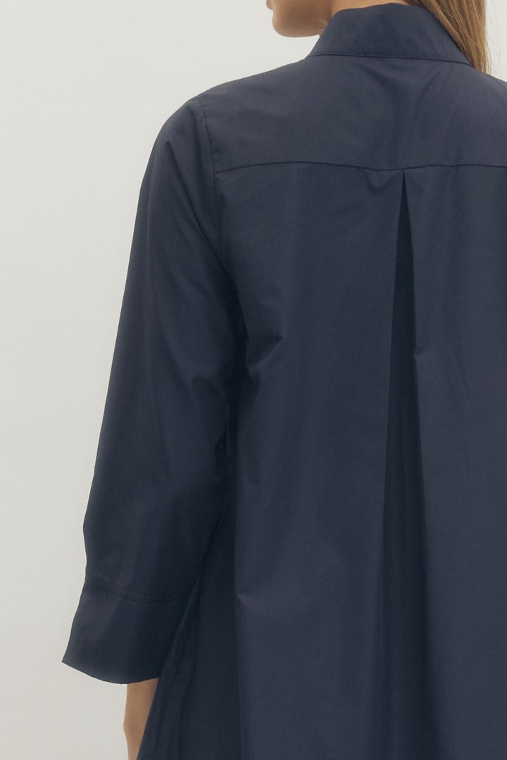 Navy blue coat worn by a person on a white background