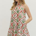 Woman wearing a patterned dress on a plain background