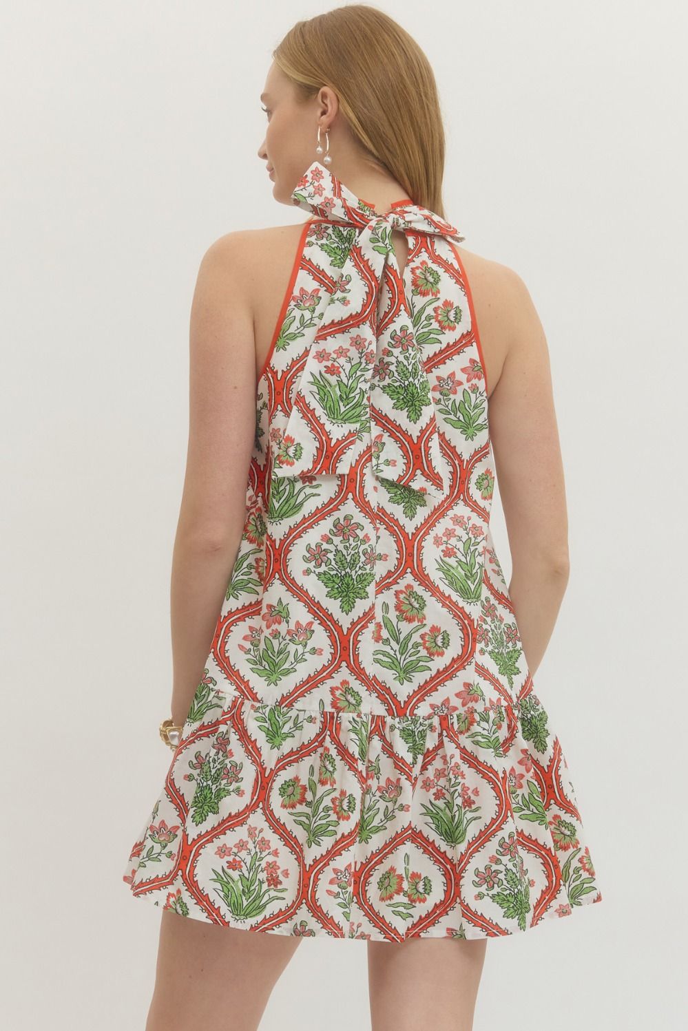 Woman wearing a patterned dress with a white background