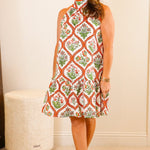 Woman in a patterned dress standing in a bedroom
