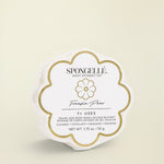 A white floral-shaped Spongelle product packaging with the brand name and product line 'Freesia Pear Daisy' prominently displayed.