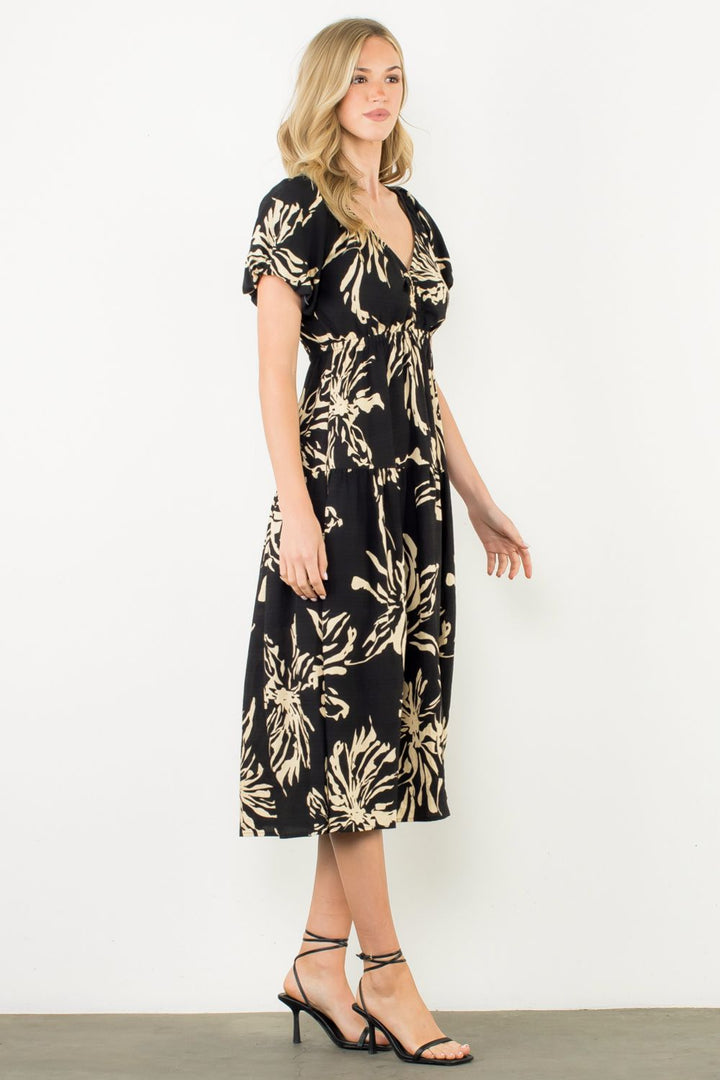 Woman wearing a black floral dress against a white background