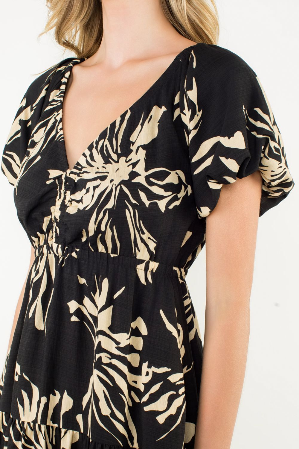 Black and beige patterned dress on a model against a white background
