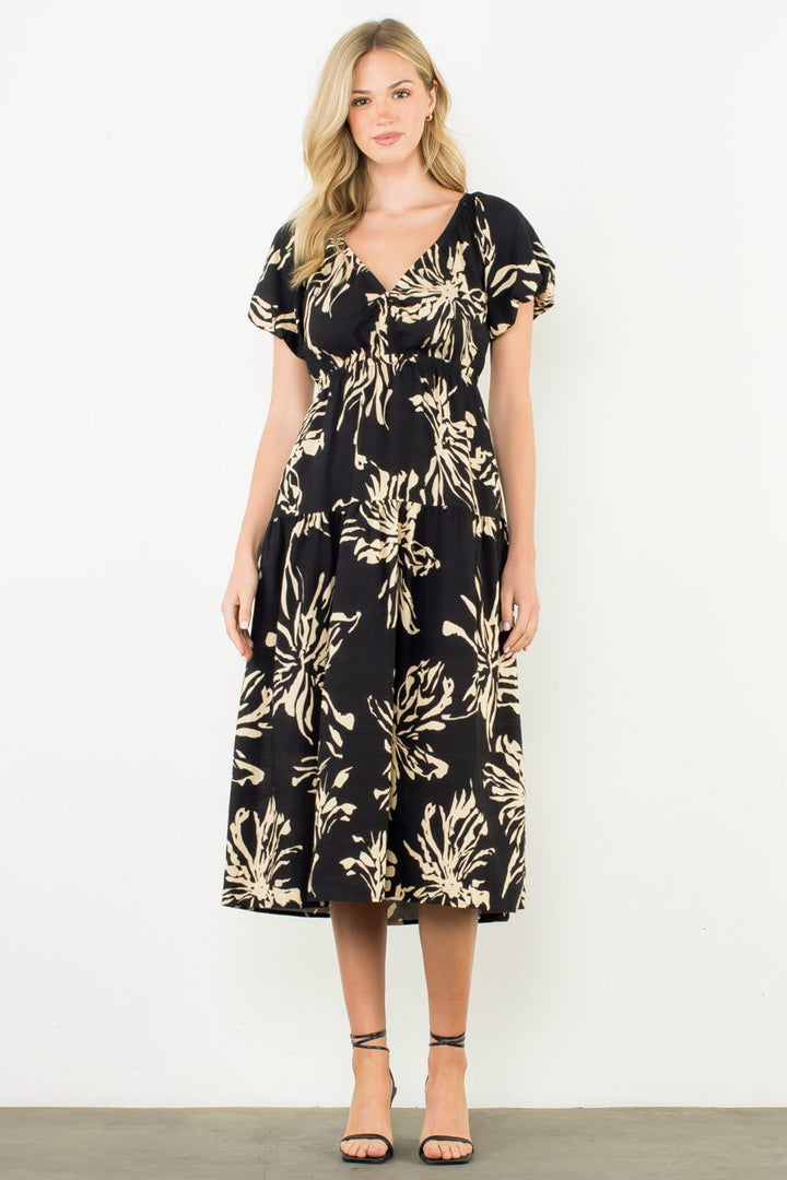 Woman wearing a black floral dress against a white background
