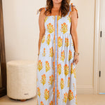 Woman in a floral dress standing in a bedroom