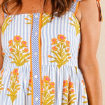 Woman in a floral dress standing in a bedroom