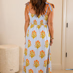 Woman in a floral dress standing in a bedroom